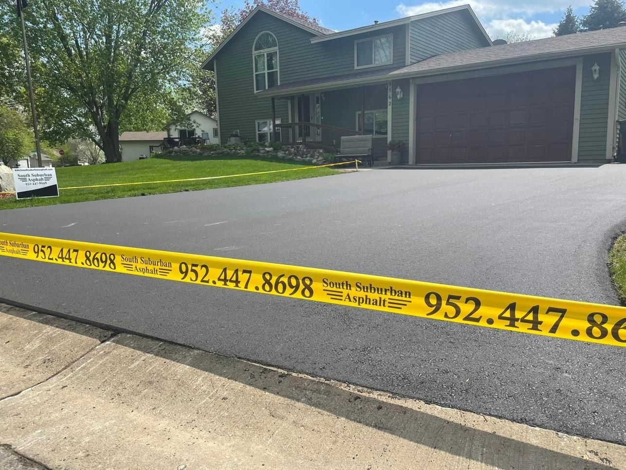 A house with a driveway that has yellow tape on it.