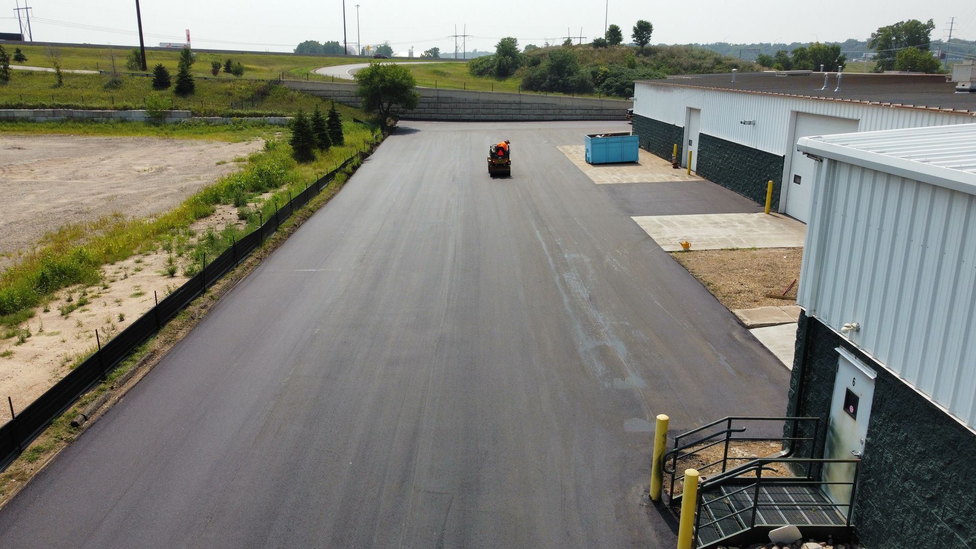 A truck is driving down a road next to a building.