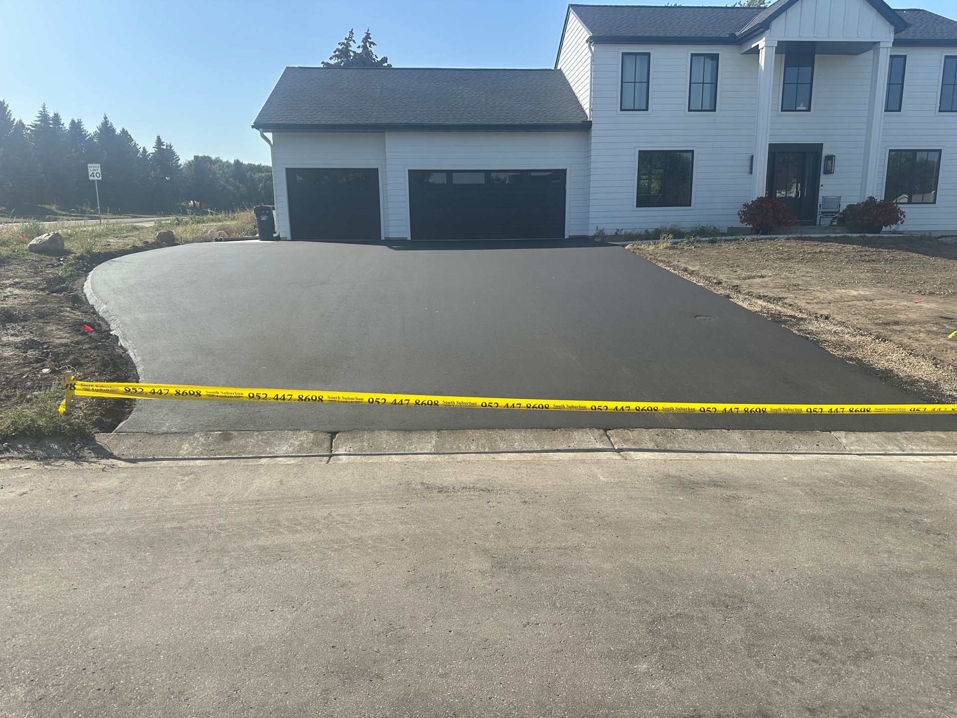 A large white house with a concrete driveway in front of it.
