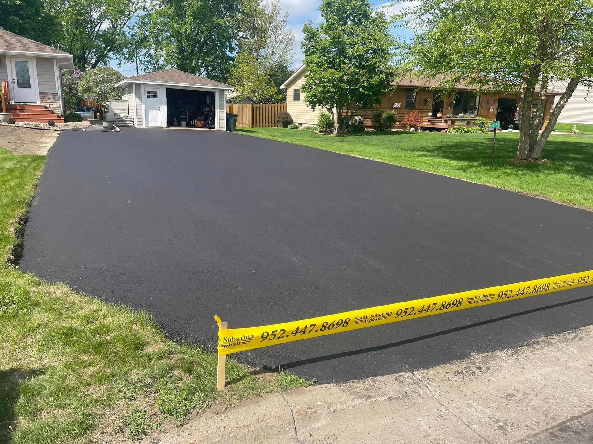 A driveway is being paved in front of a house.
