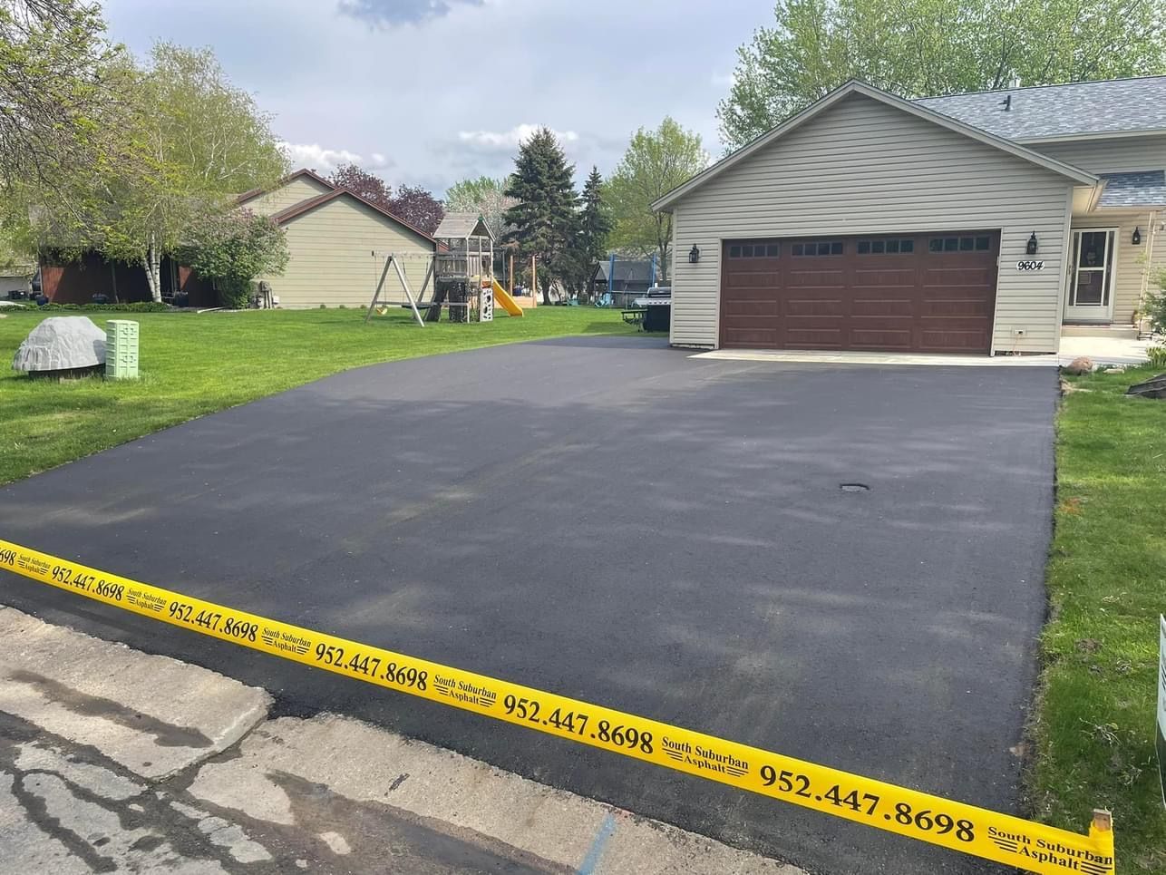 A driveway in front of a house with a yellow tape around it.