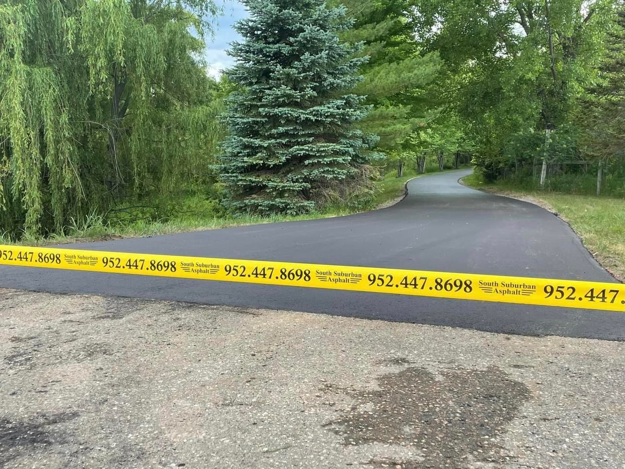 A road with a yellow tape along the side of it.