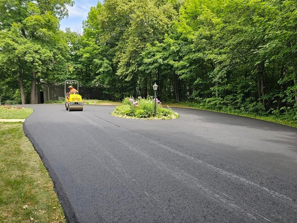 A yellow truck is driving down a road surrounded by trees.
