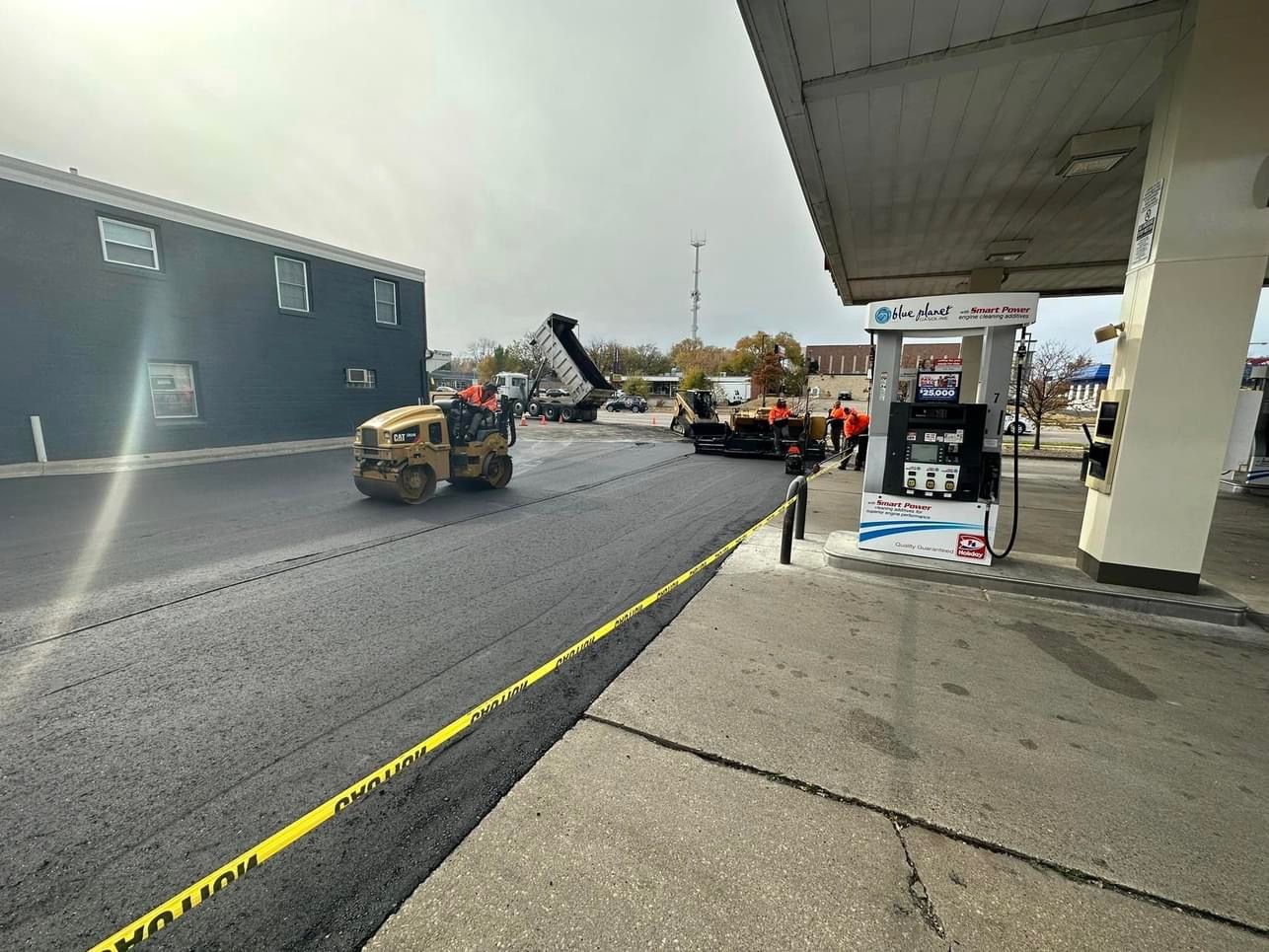 A road is being paved in front of a gas station.