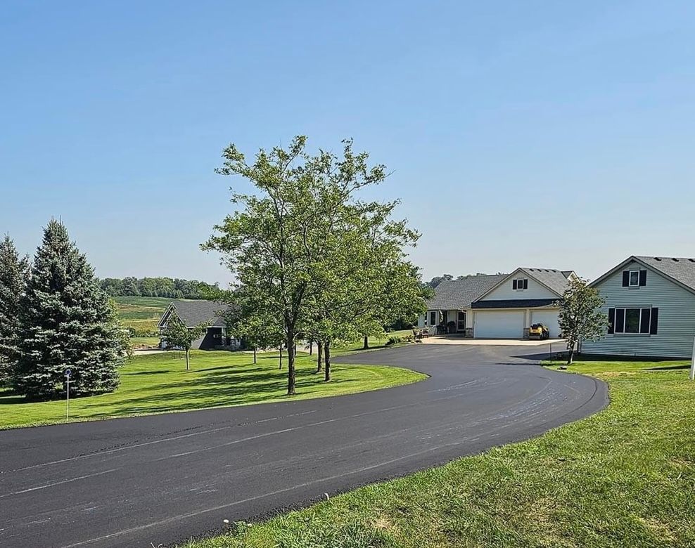A driveway leading to a house with a blue sky in the background