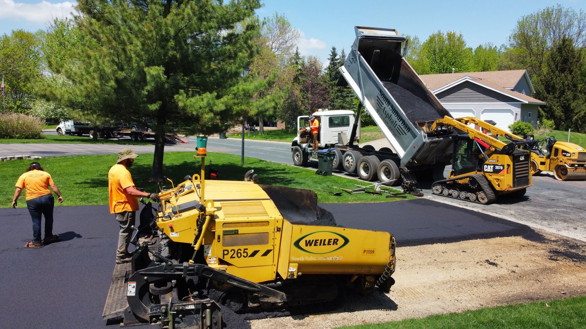 A group of construction workers are working on a driveway.