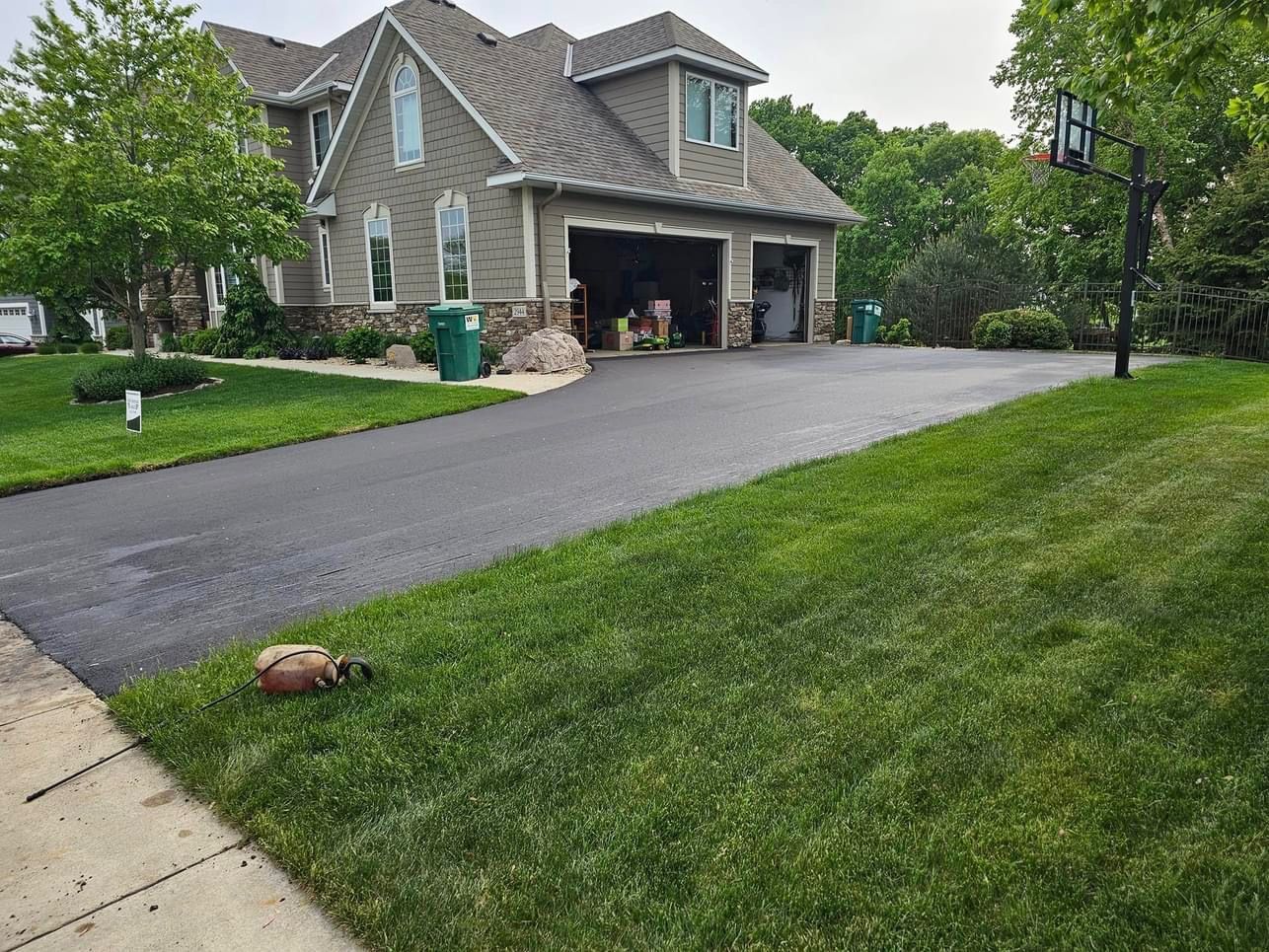 A large house with a driveway and a basketball hoop in front of it.