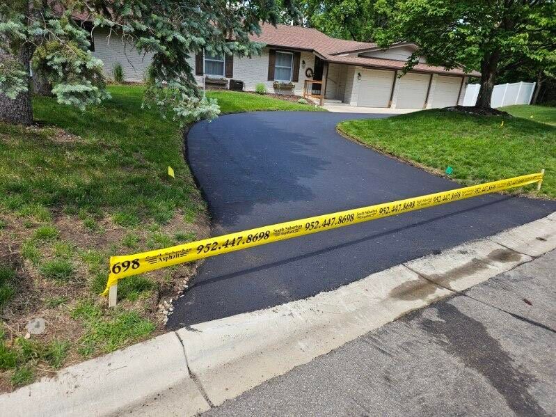 A driveway is being paved in front of a house.