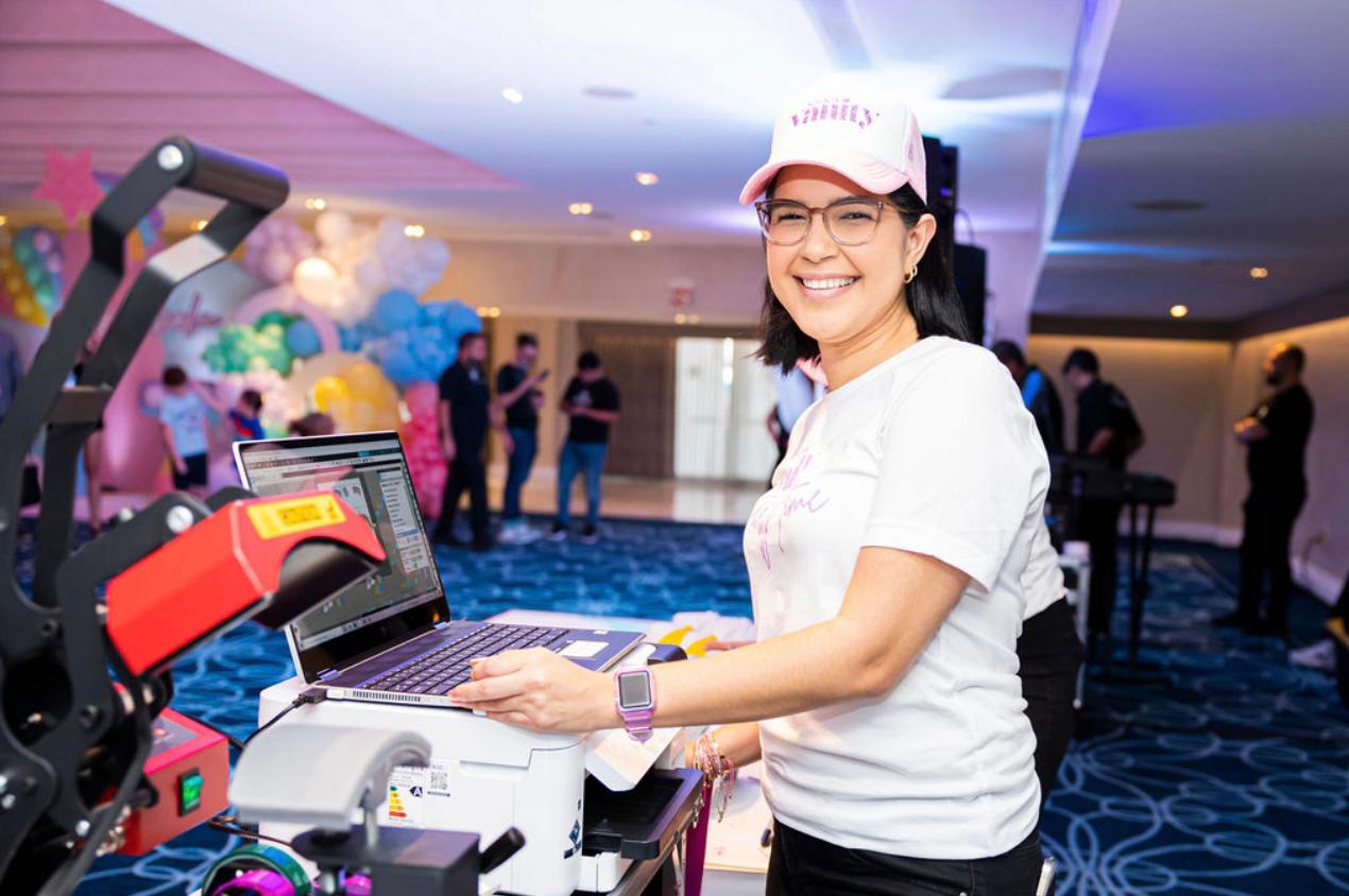 Una mujer está parada frente a una computadora portátil en una habitación.