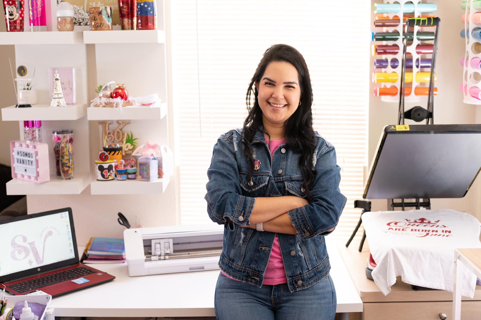 Una mujer está parada frente a un escritorio con los brazos cruzados.