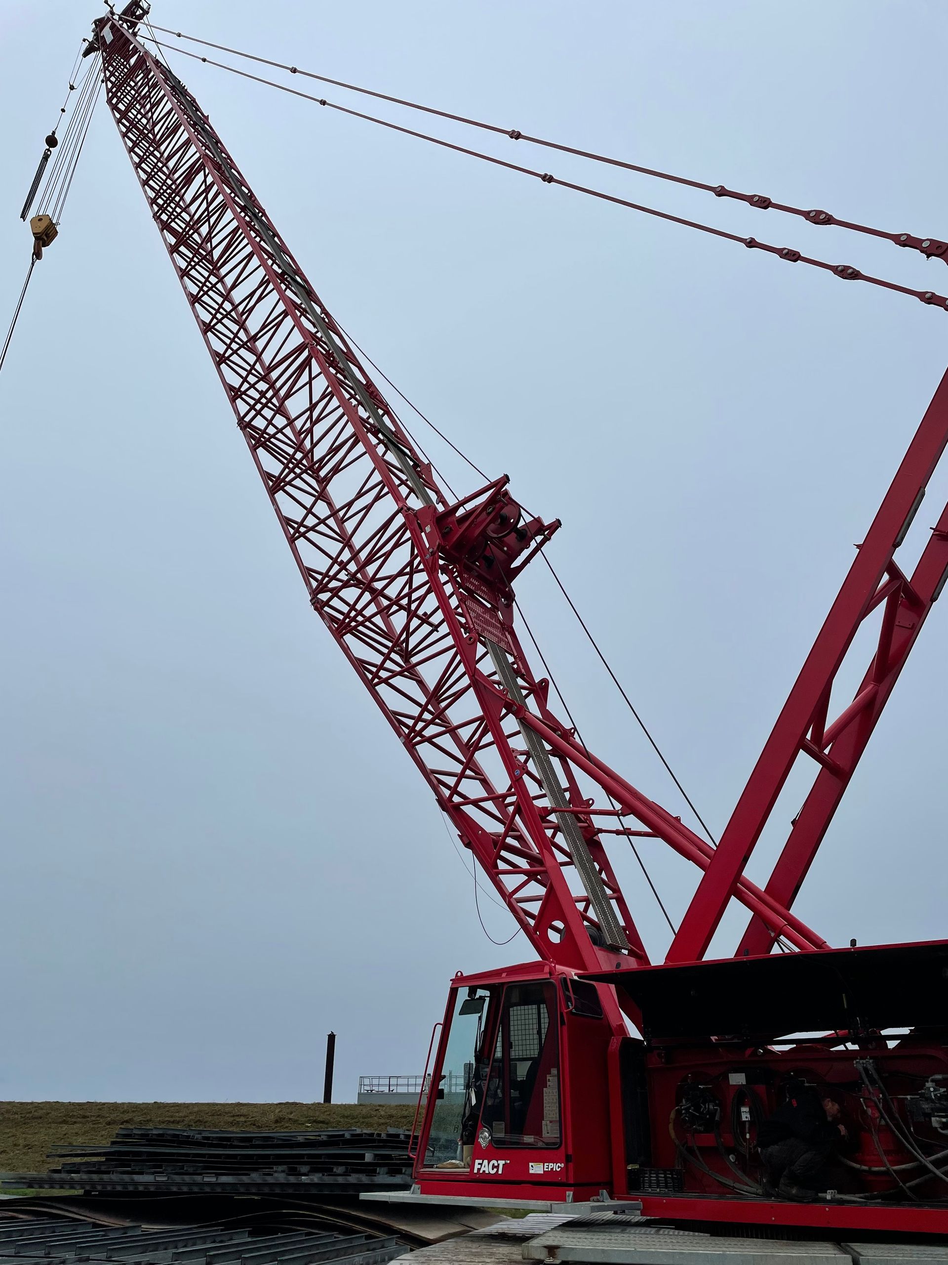 Red construction crane against a cloudy sky.