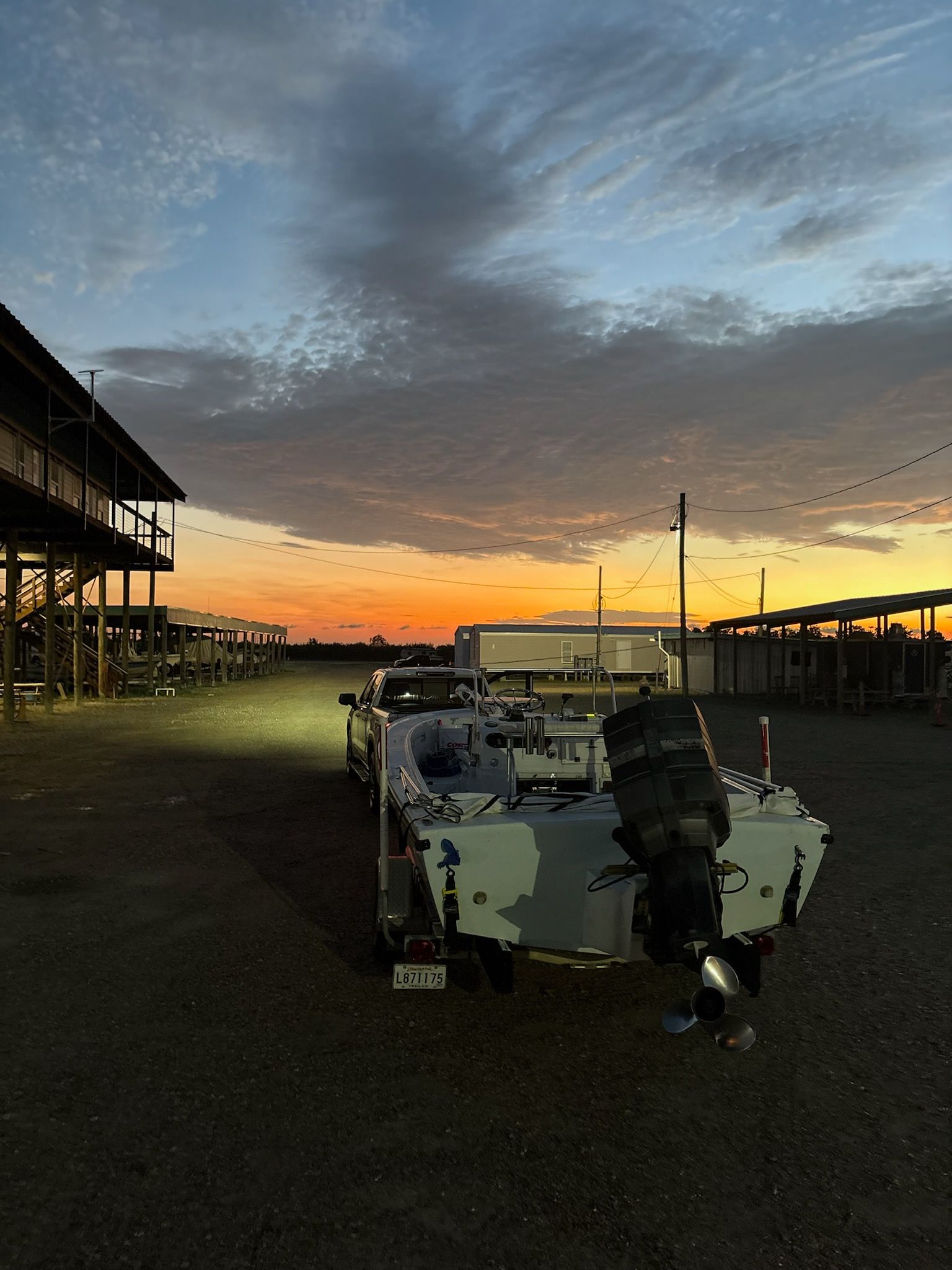 Boat on trailer with sunset backdrop; building on the left.