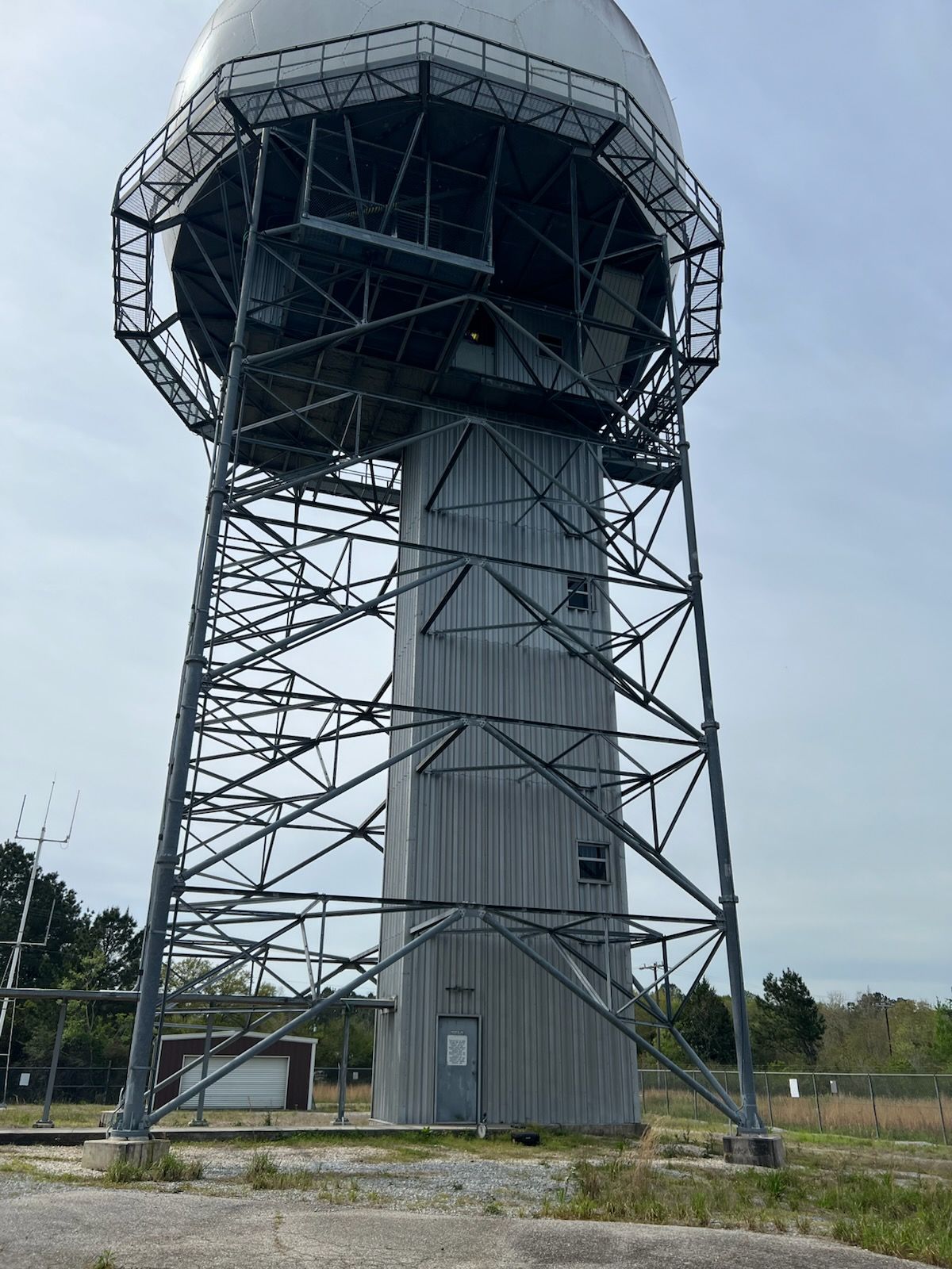 Weather radar tower with a white dome on a metal framework structure.