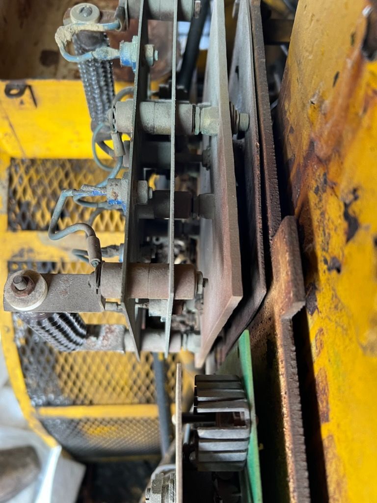 Close-up view of electrical components within a yellow machine, showing wires, metal plates, and circuits.