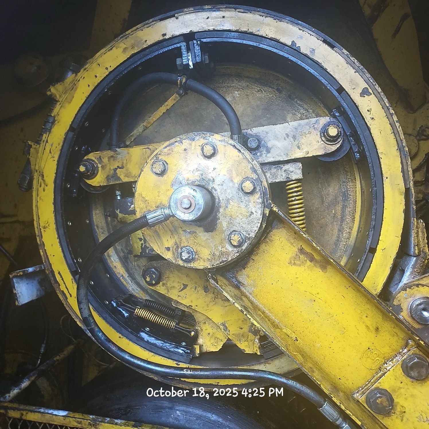 Yellow industrial machine component with hydraulic lines and central hub, October 18, 2025.