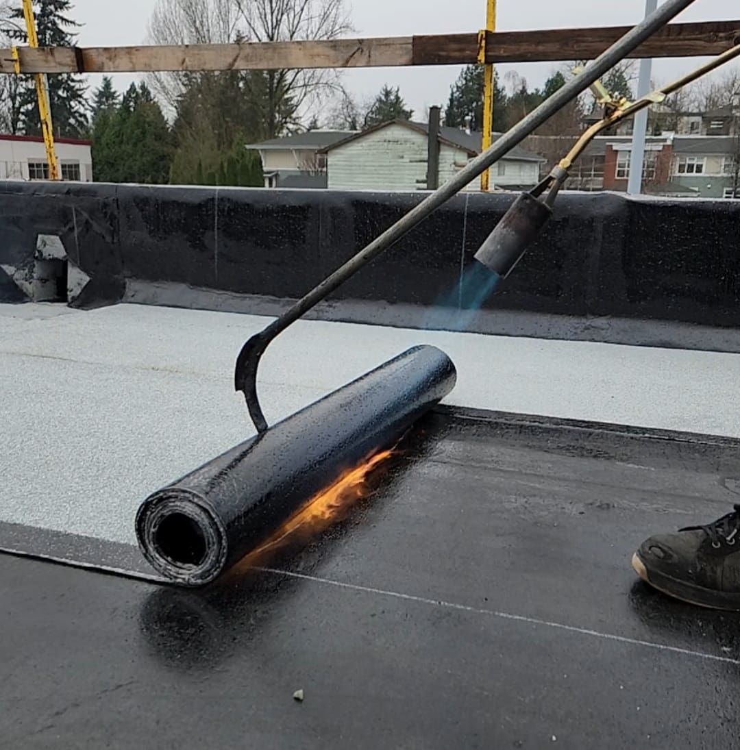 A man performs roof maintenance, replacing broken shingles with new ones on an uncovered roof.