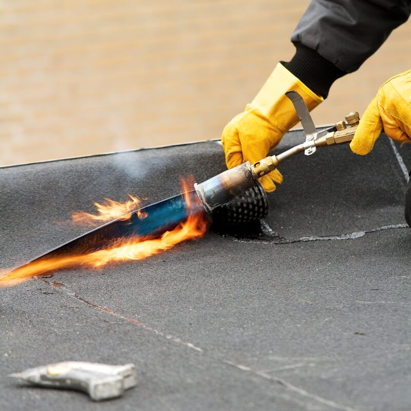 A skilled worker repairing a damaged roof, meticulously replacing shingles and reinforcing the structure to ensure durability and protection against the elements.