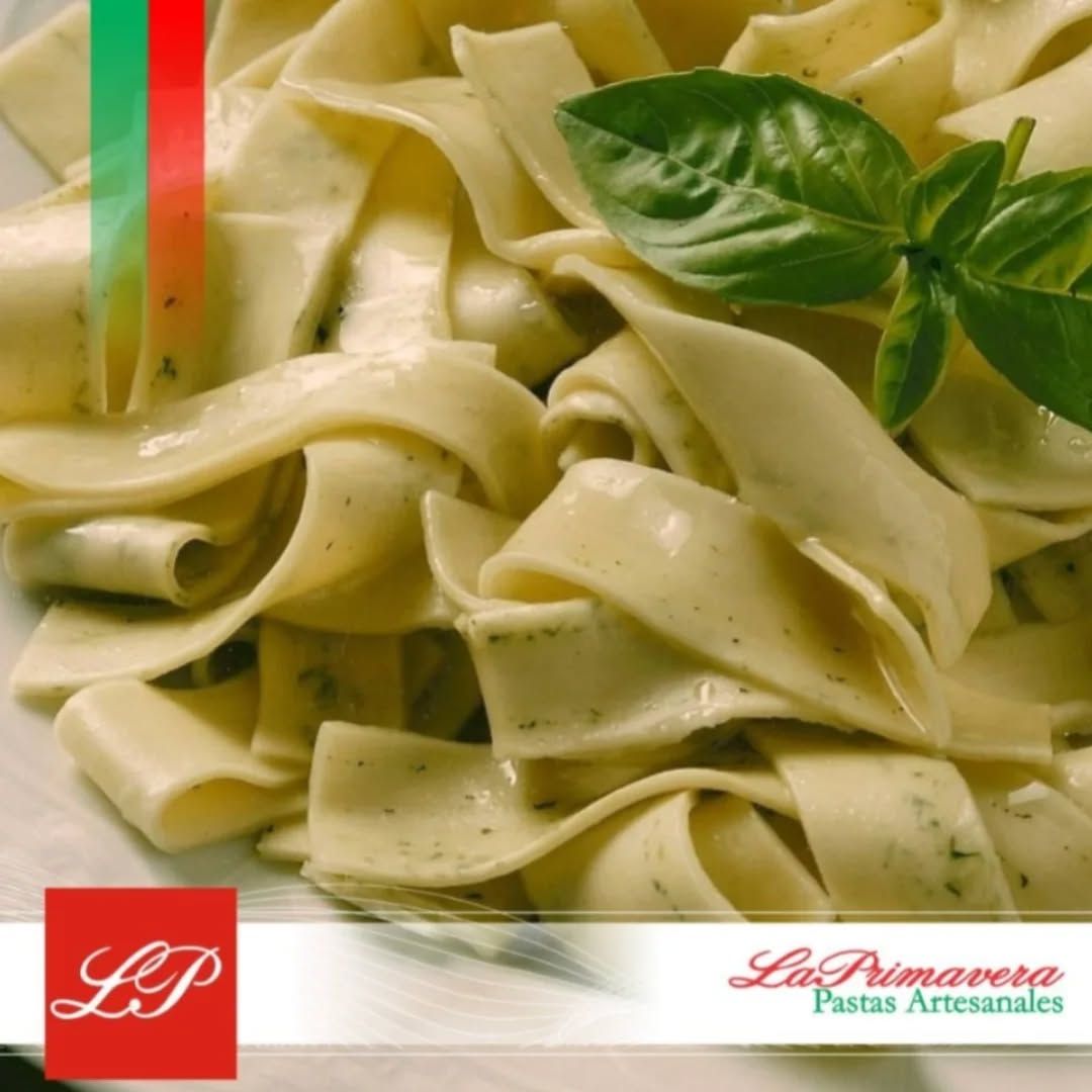 Pasta con salsa pesto, con albahaca. Primer plano en un plato, con el logotipo de la marca.