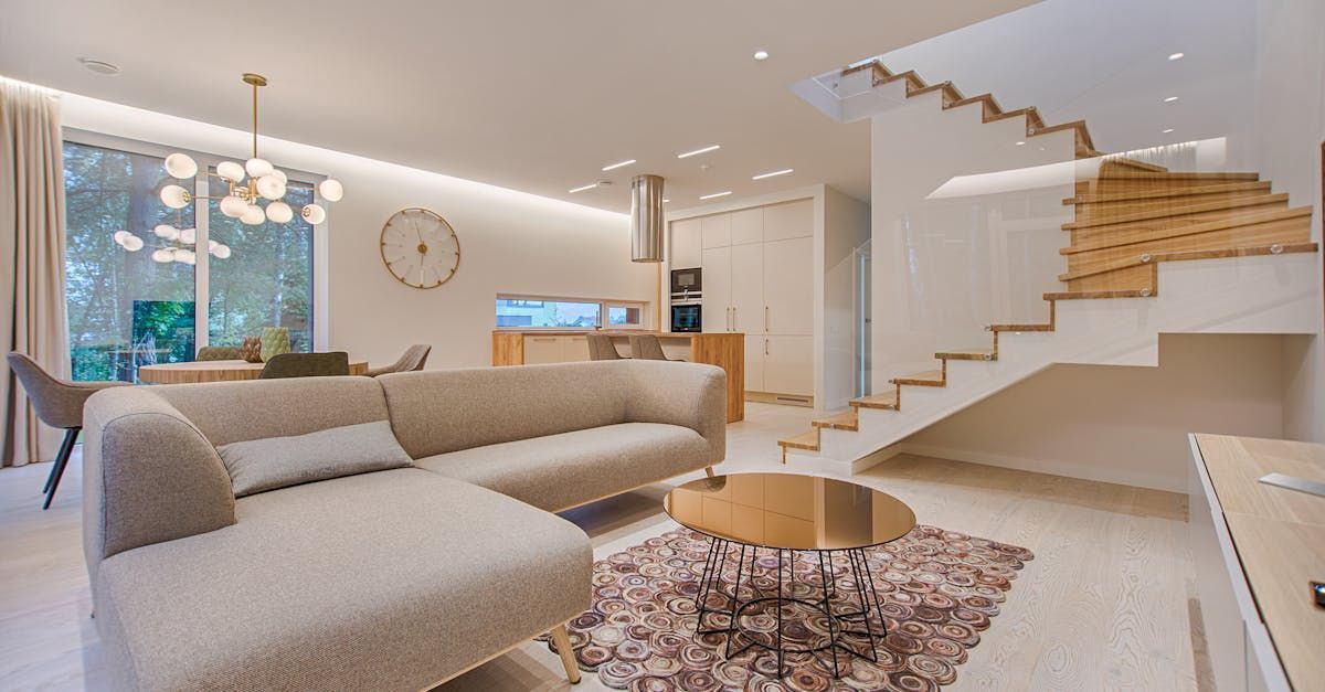 A living room with a couch, coffee table, and stairs.
