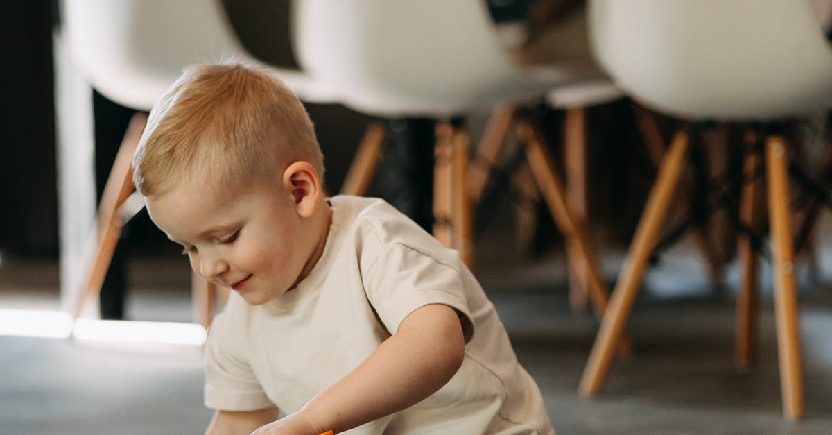 A little boy is playing with a toy on the floor.