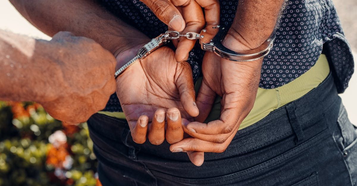 A man handcuffing the arrested person.