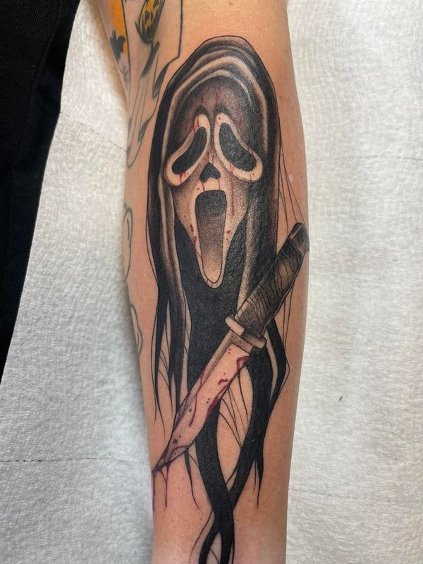 A person has a scream tattoo on their forearm.