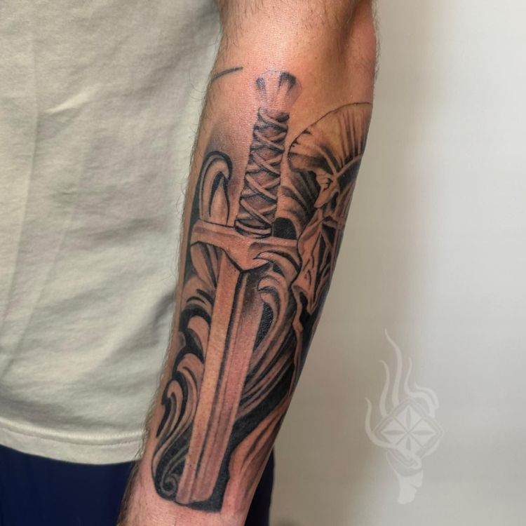 a mans arm with sword tattoo