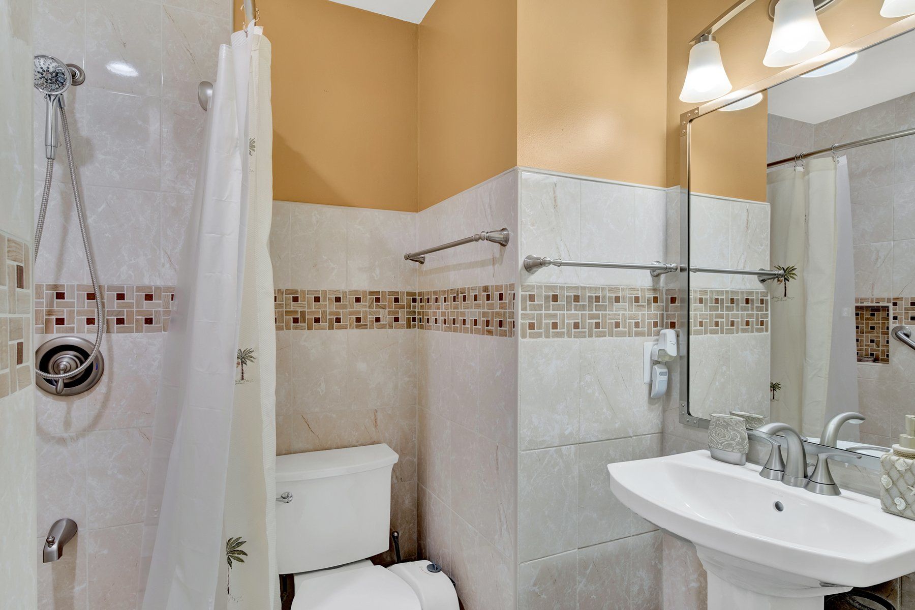 A bathroom with a sink , toilet , shower and mirror