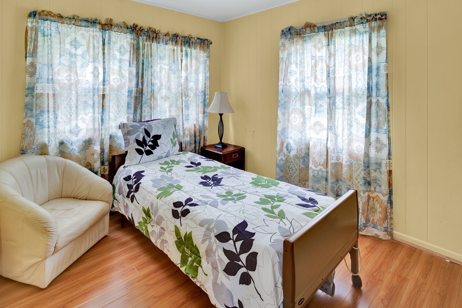 A bedroom with a single bed and a chair