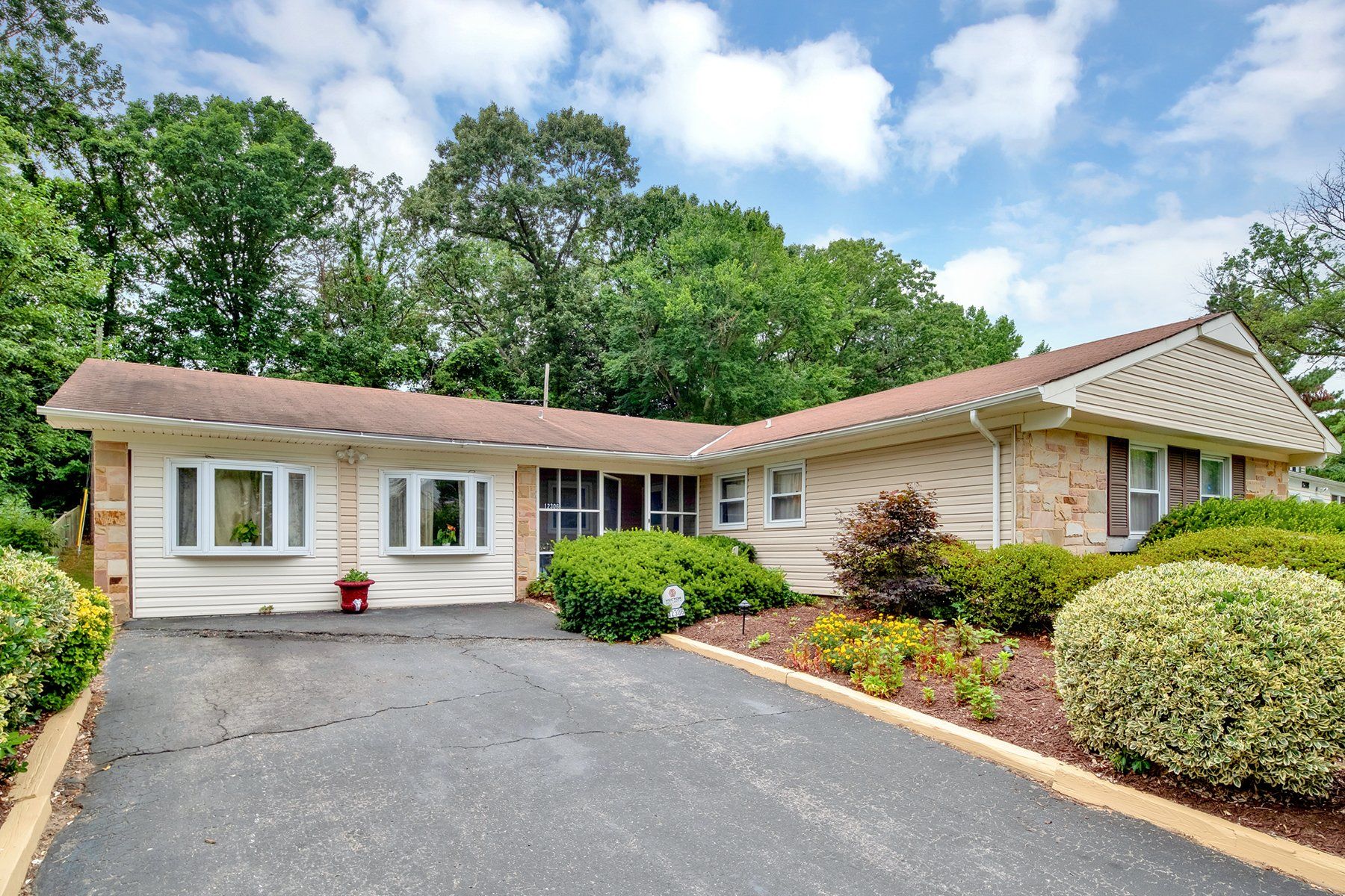 A white house with a brown roof is for sale
