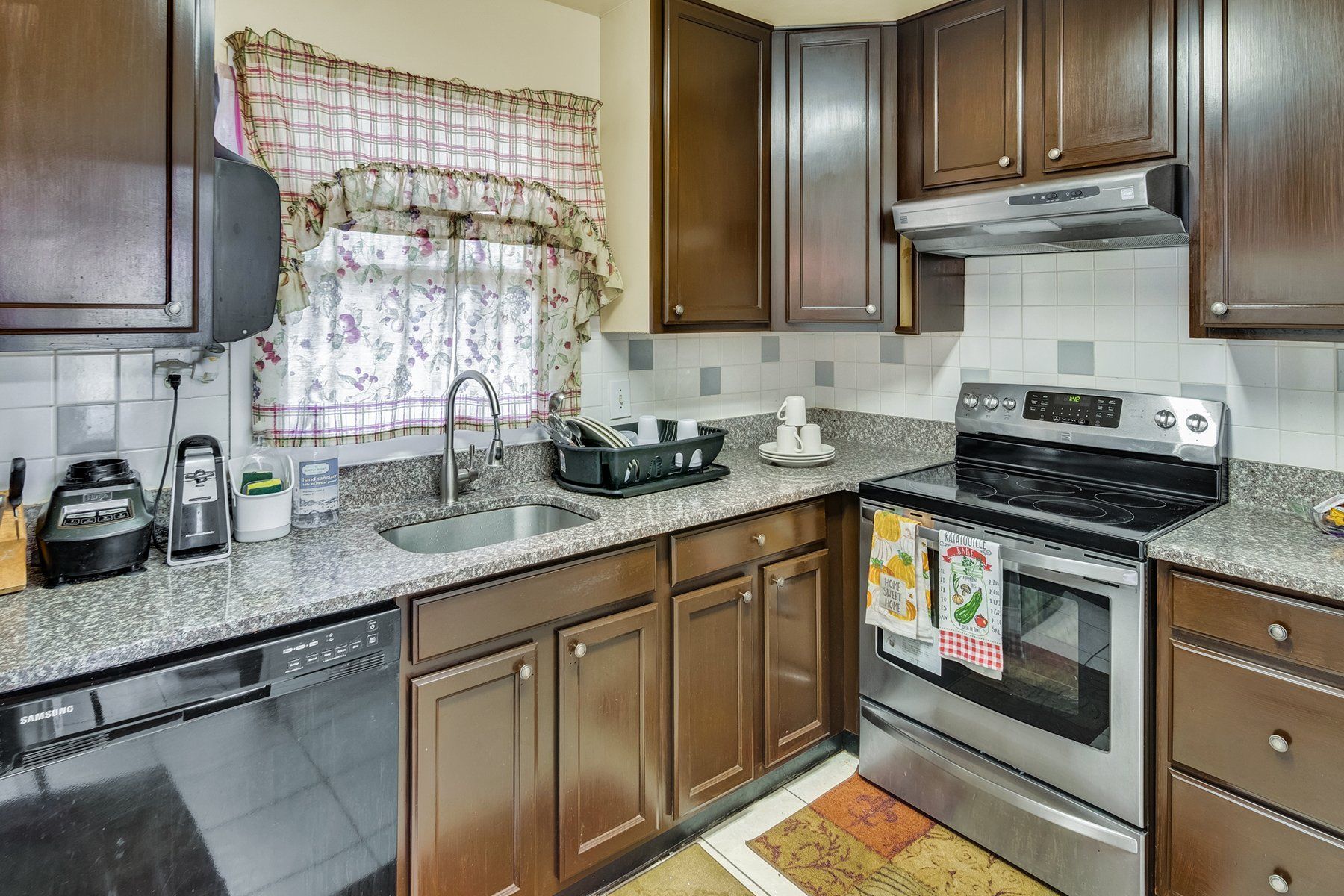 A kitchen with stainless steel appliances and wooden cabinets