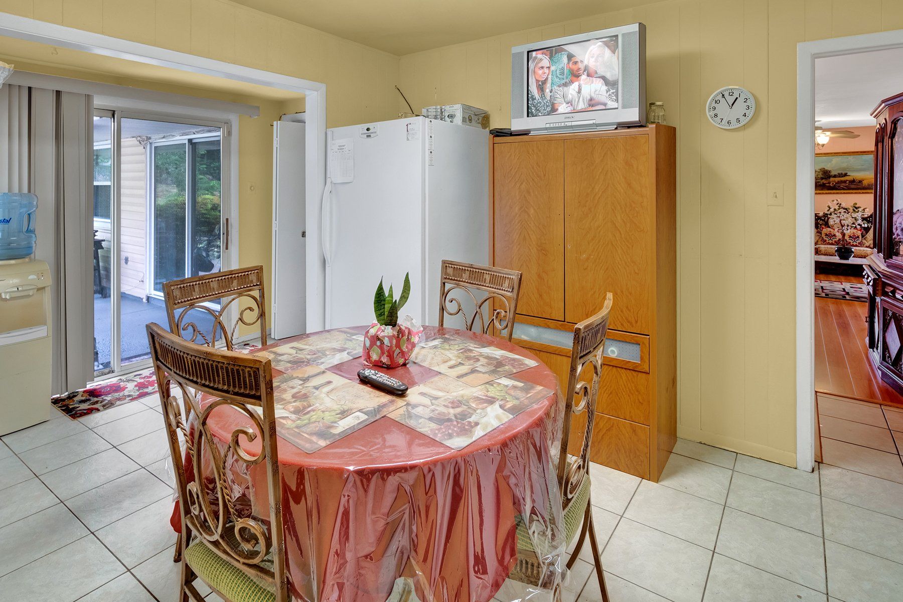 A kitchen with a table and chairs and a television