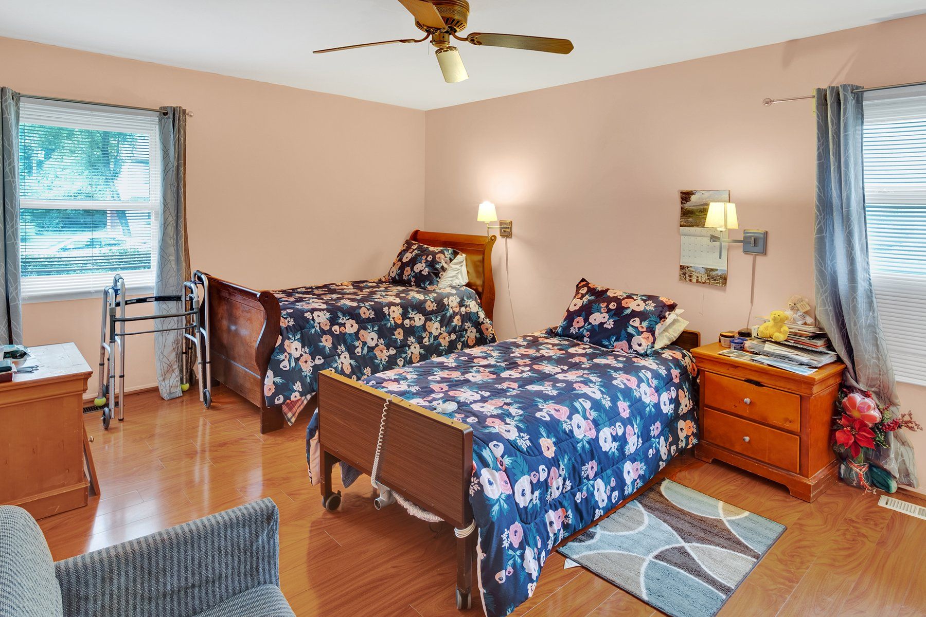 A bedroom with two beds and a ceiling fan.