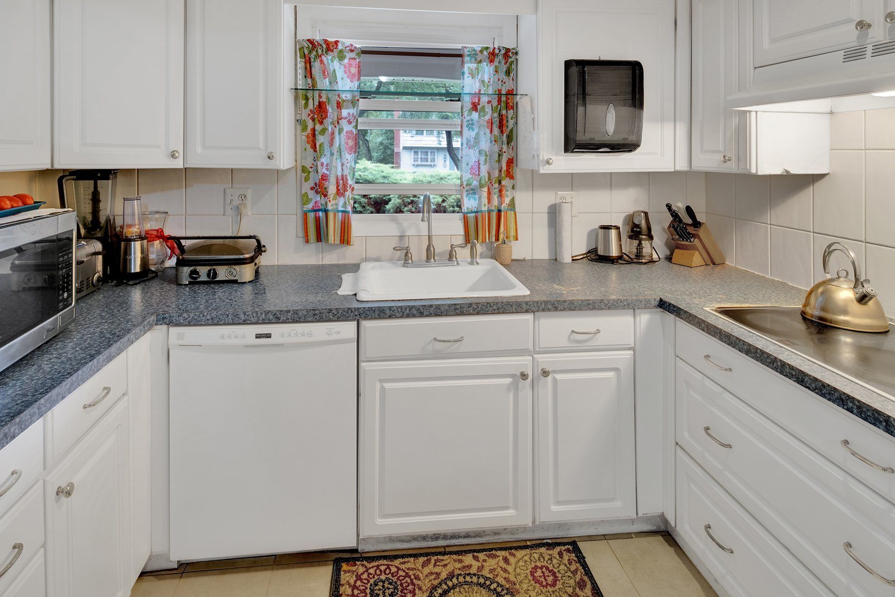 A kitchen with white cabinets and granite counter tops