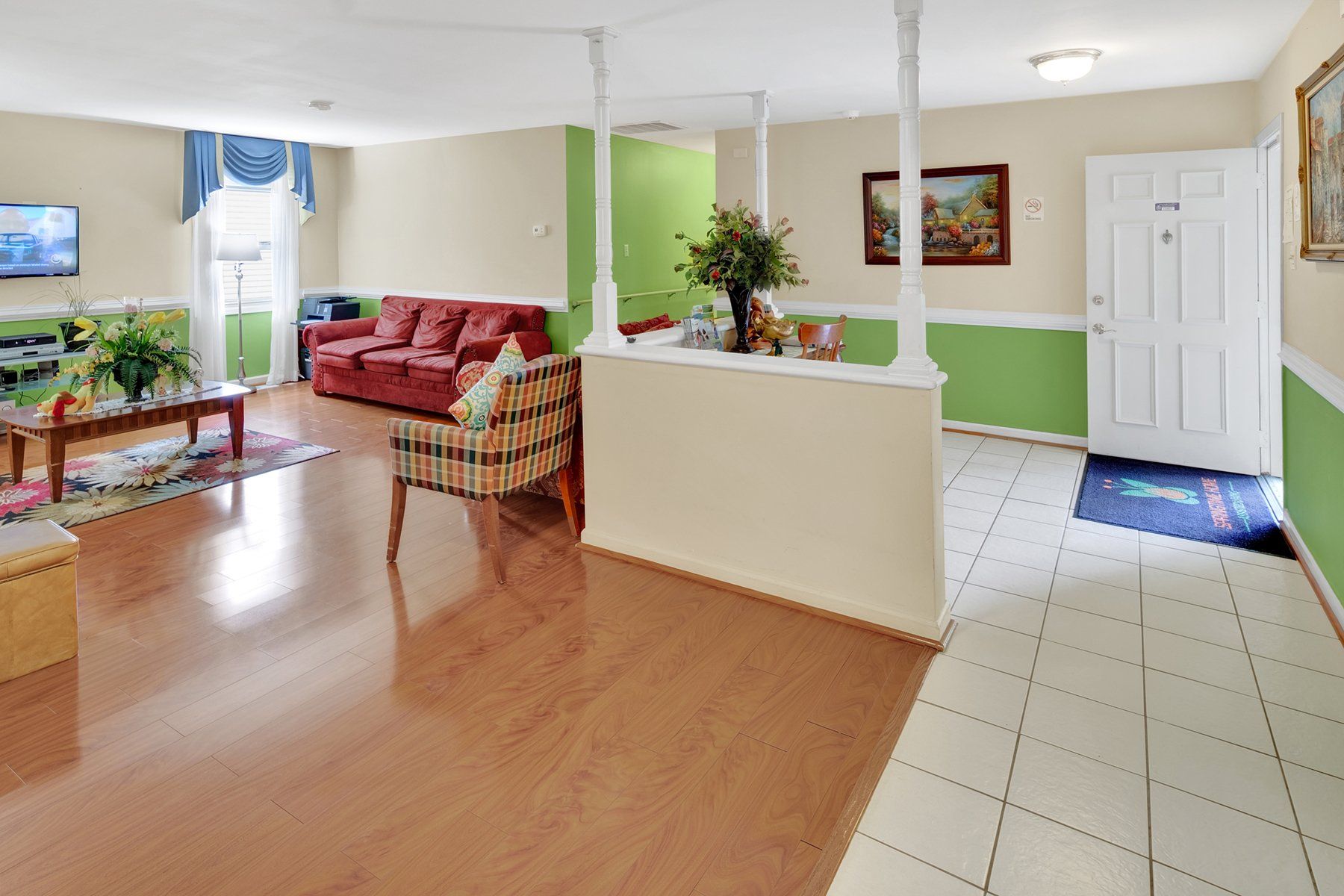 A living room with a couch , chair , coffee table and television.