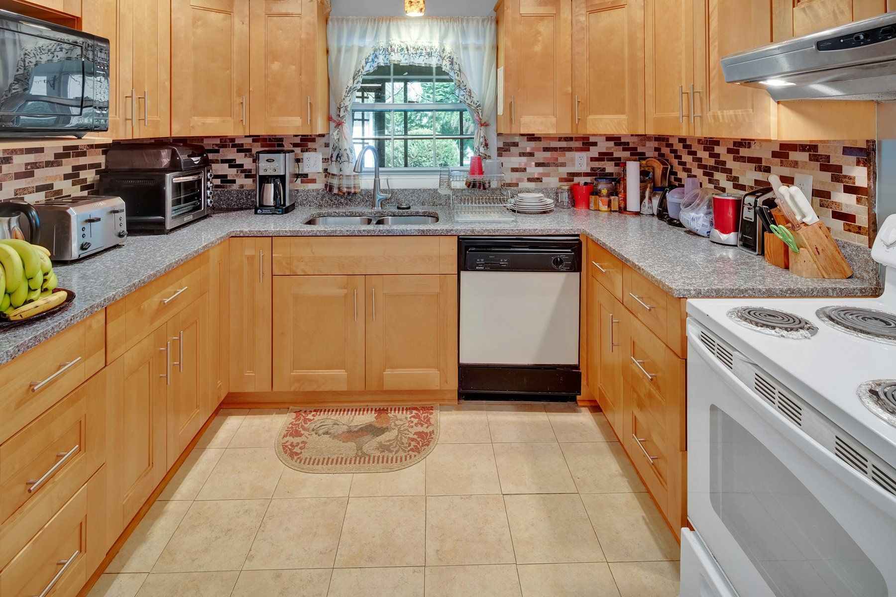 A kitchen with wooden cabinets and granite counter tops