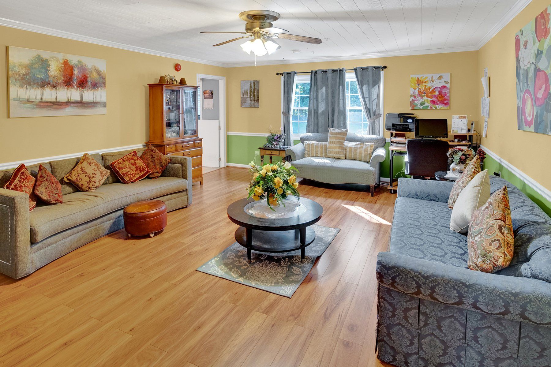 A living room filled with furniture and a ceiling fan.