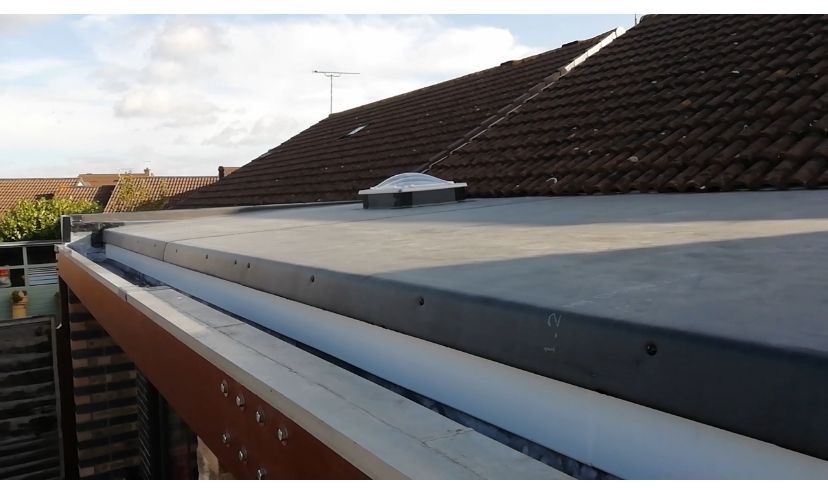 A roof with a gutter and a skylight on it