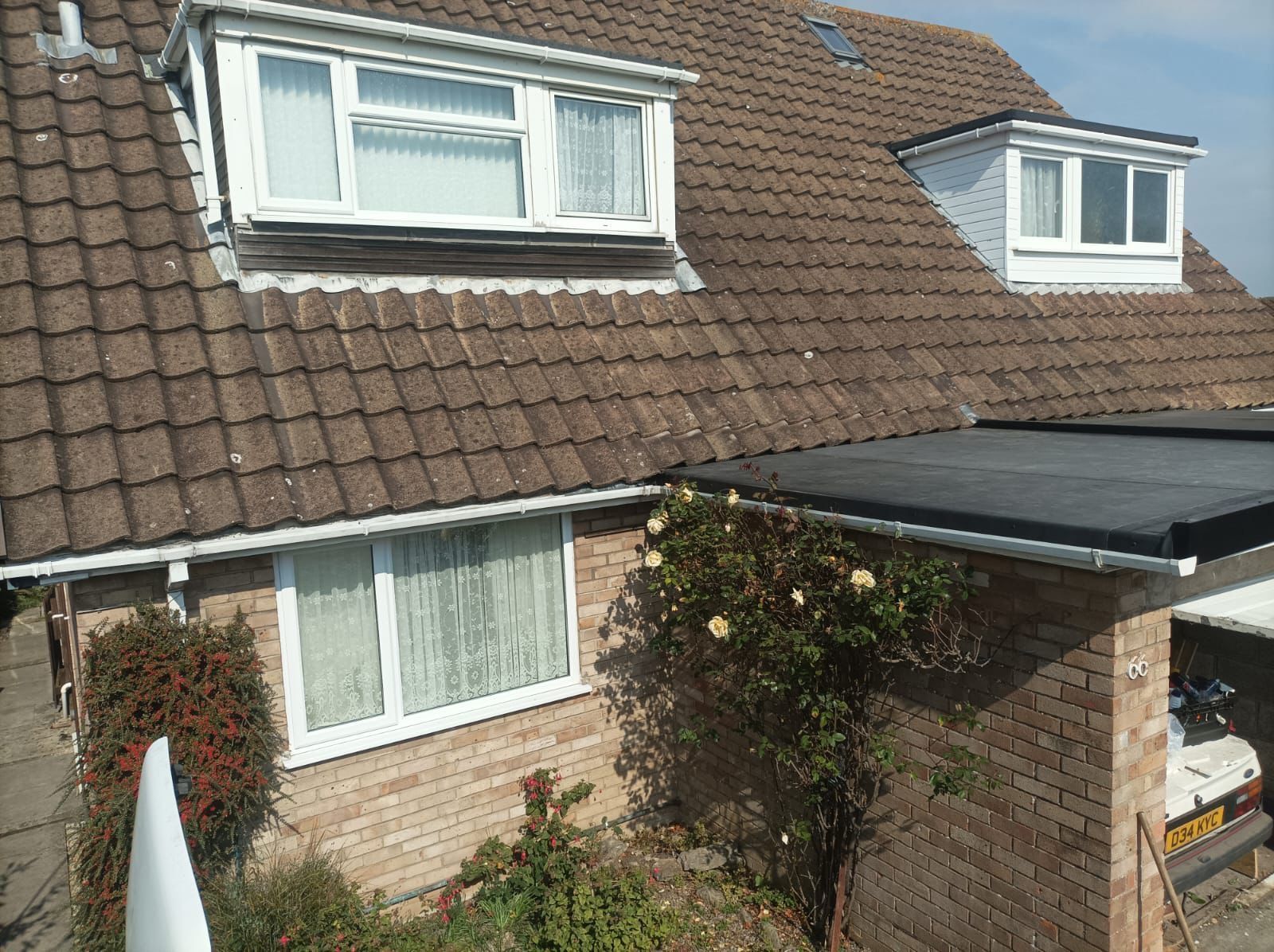 A brick house with a tiled roof and a garage.