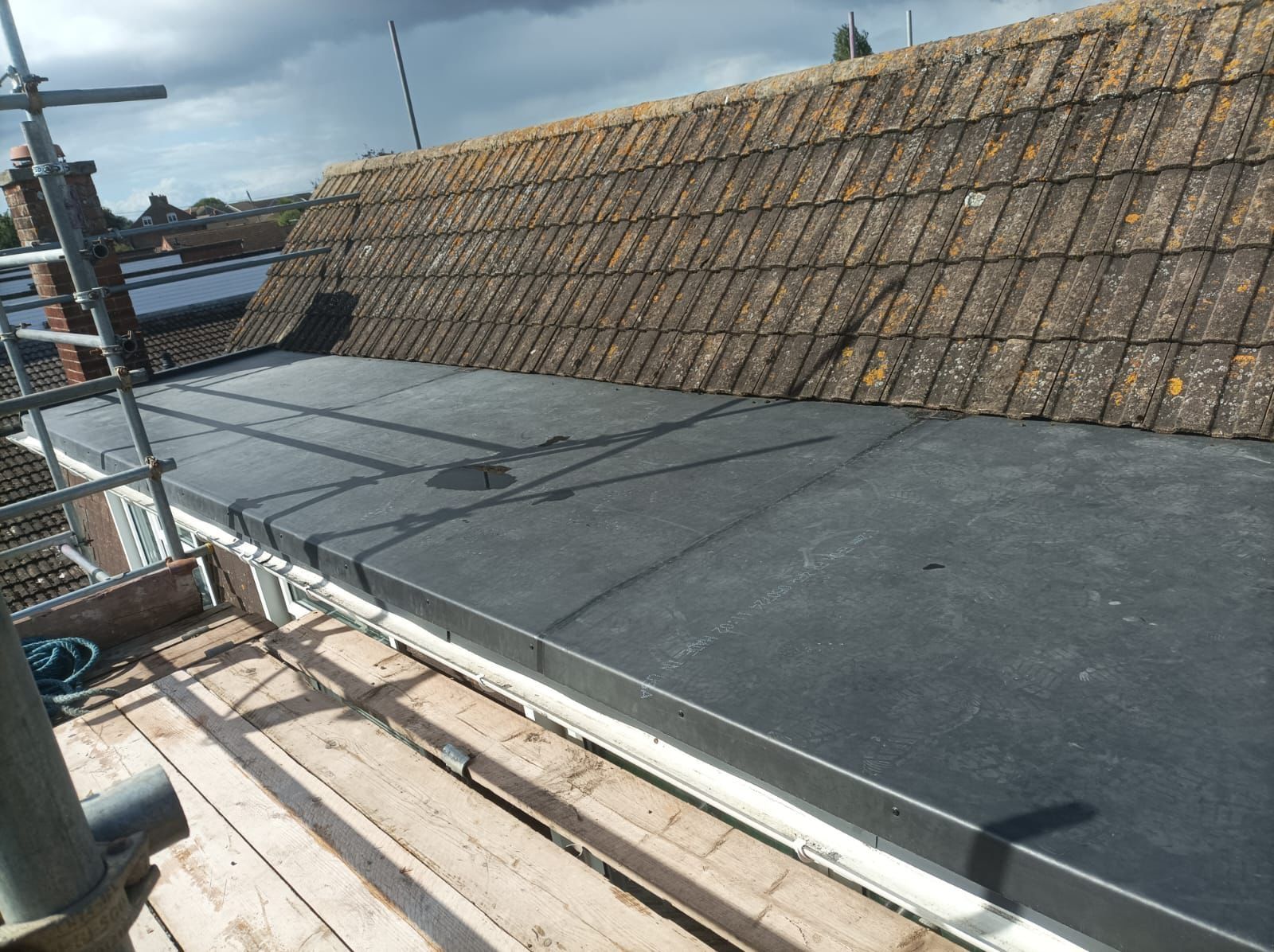A roof with a black roof and a wooden scaffolding on it.