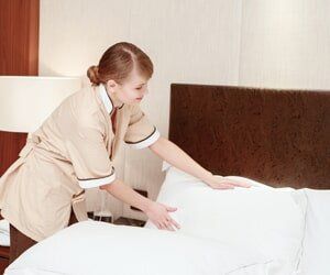 Maid fluffing the pillows - Home Cleaning Service in Raleigh, NC