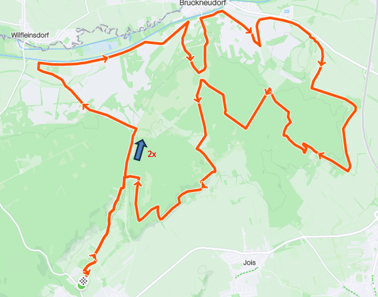 Eine orangefarbene GPS-Route ist auf einer grünen Karte eingezeichnet, in der Nähe der Mitte befindet sich ein kleiner blauer Pfeil.
