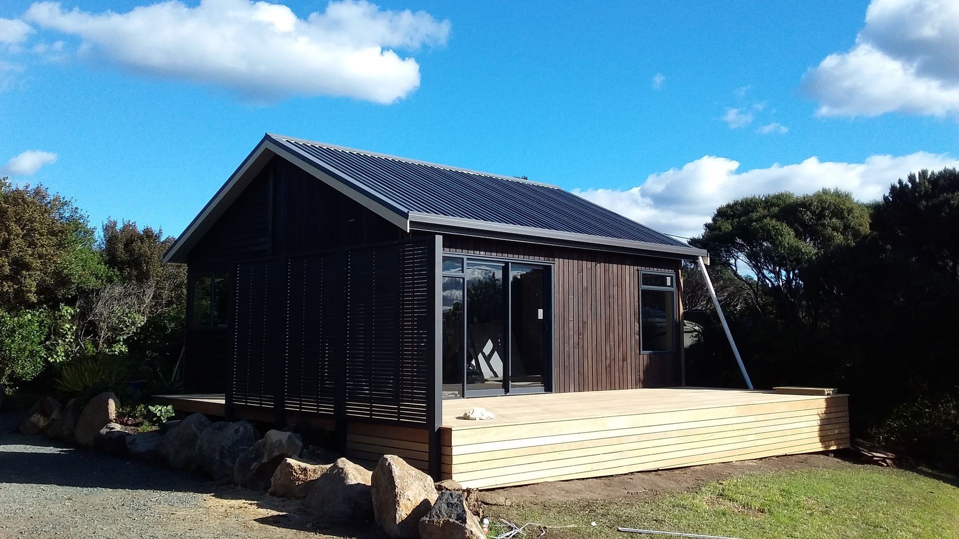 A small house with a wooden deck in front of it