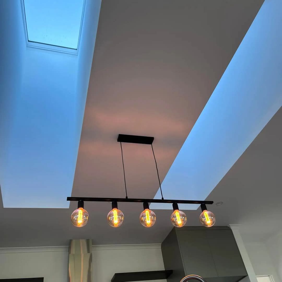 A ceiling with a skylight and four lights hanging from it