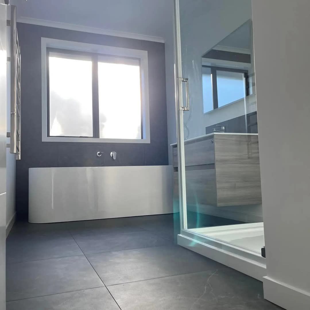 A bathroom with a bathtub and a window