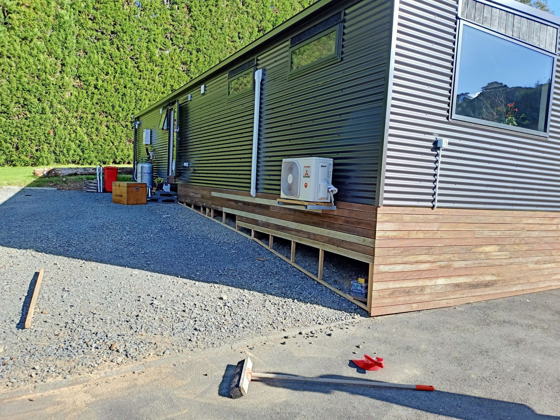 A large building with a lot of windows is sitting on top of a gravel road.