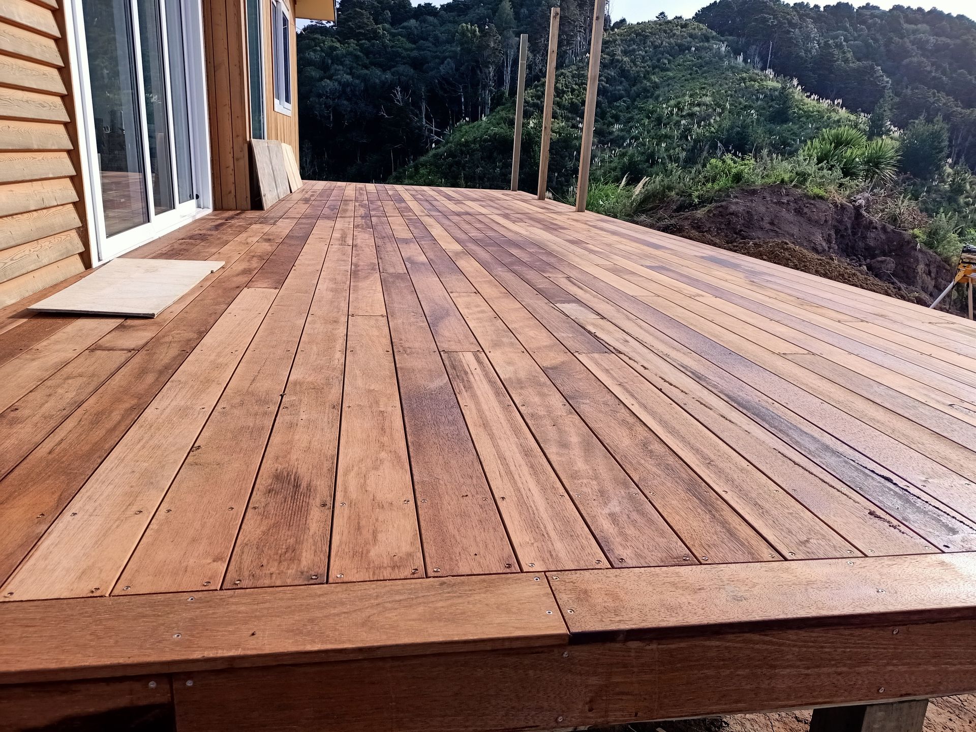 A wooden deck with a house in the background