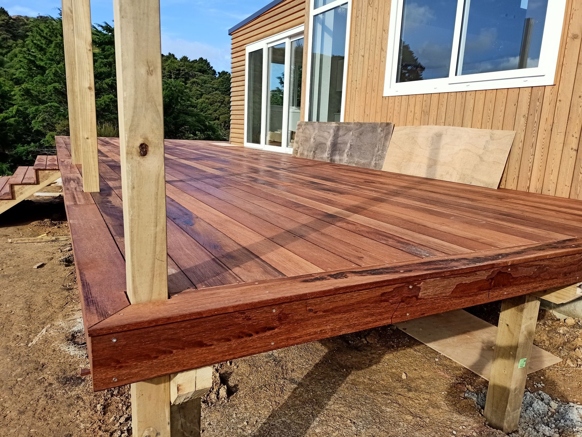 A wooden deck is being built in front of a house.