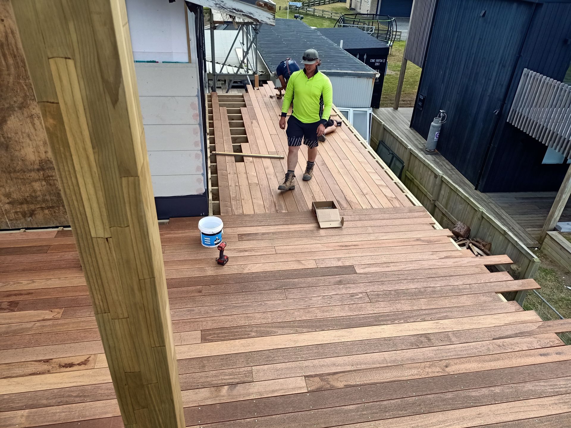 A man is standing on top of a wooden deck.