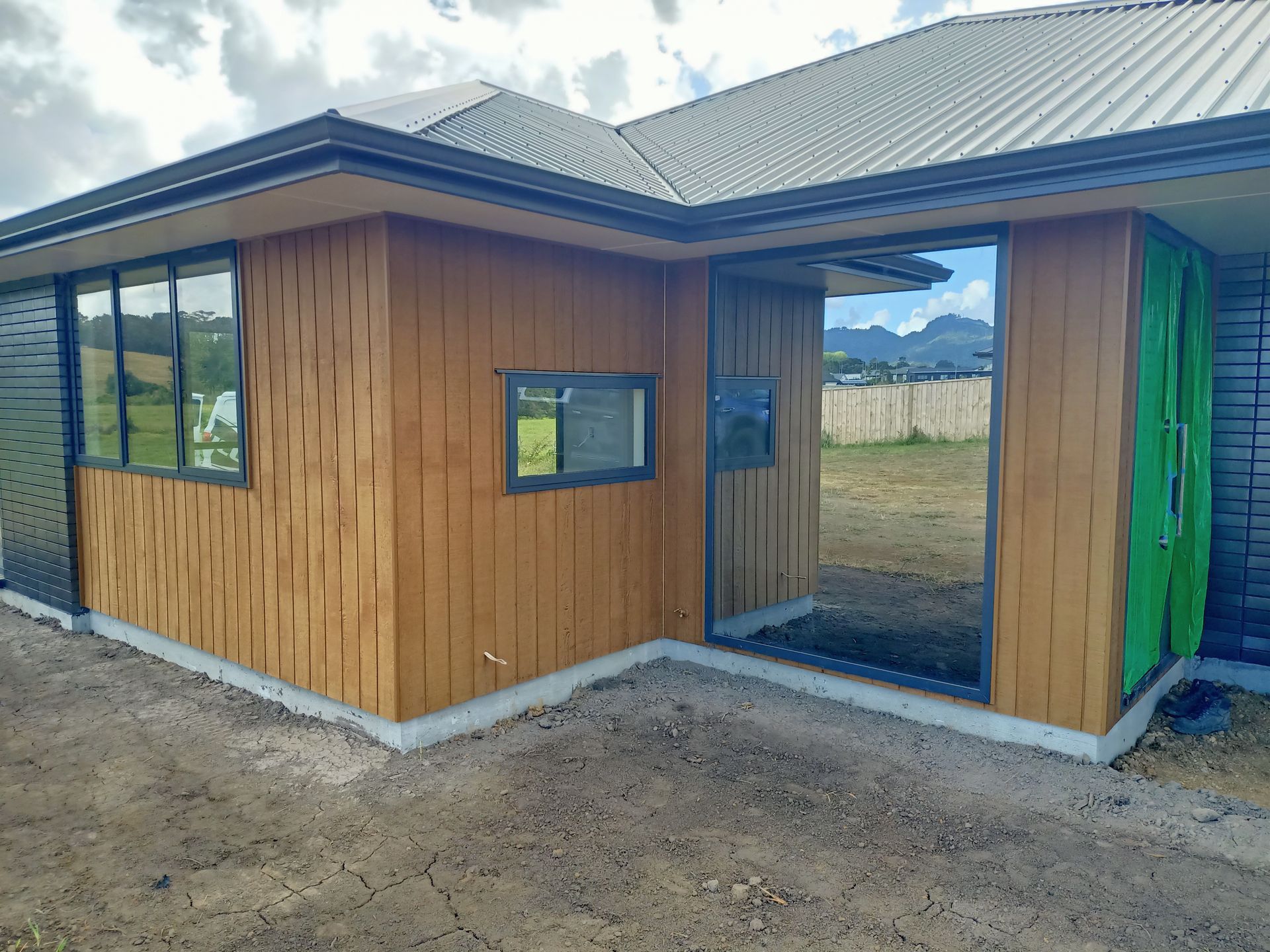 A house with wooden siding and windows is being built.